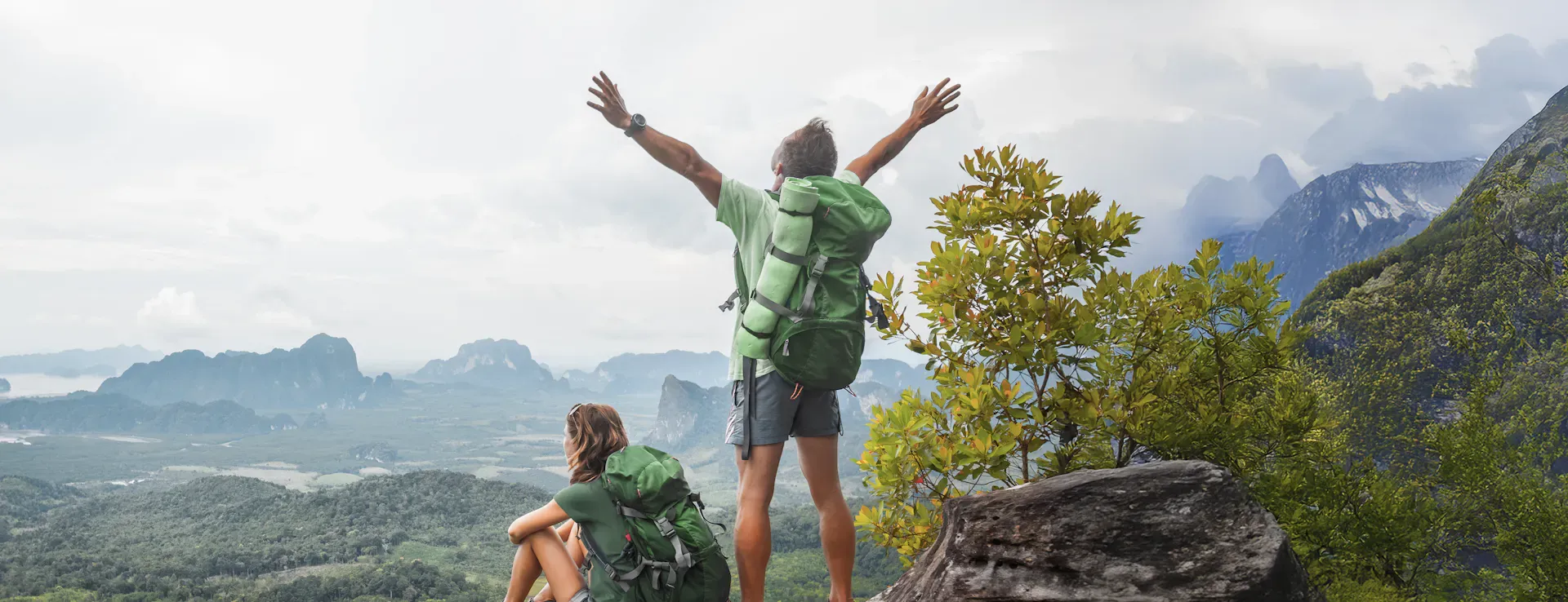 hikers standing on top of mountain enjoying and cheering because of the view